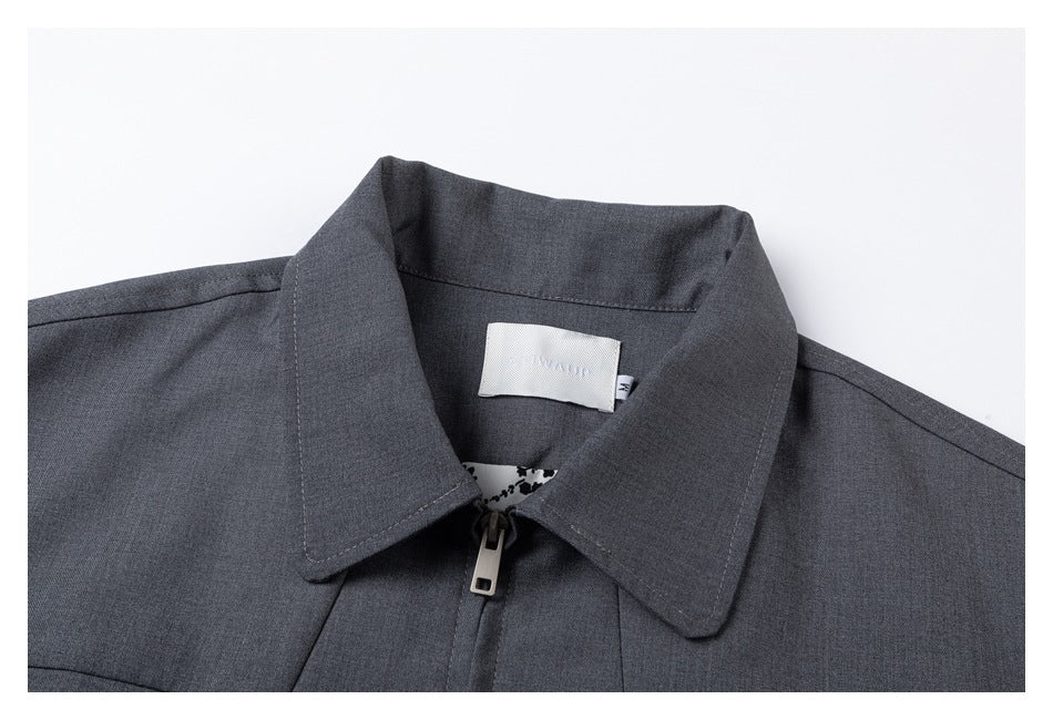 Close-up of the gray jacket's collar, zipper, neck label, and patterned inner facing.