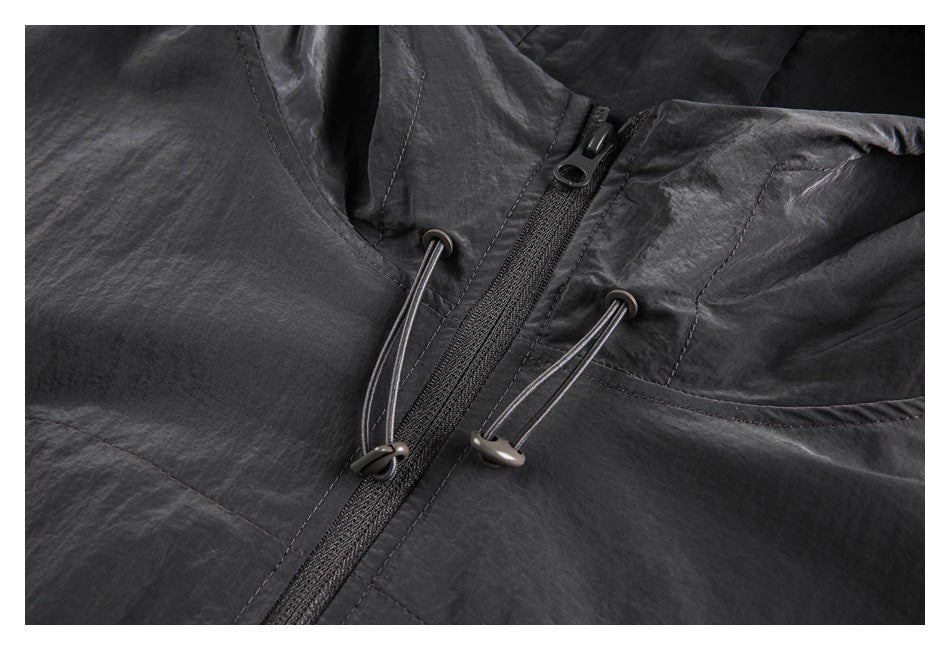 Close-up of the charcoal jacket's front zipper and adjustable hood drawcords with toggle ends.