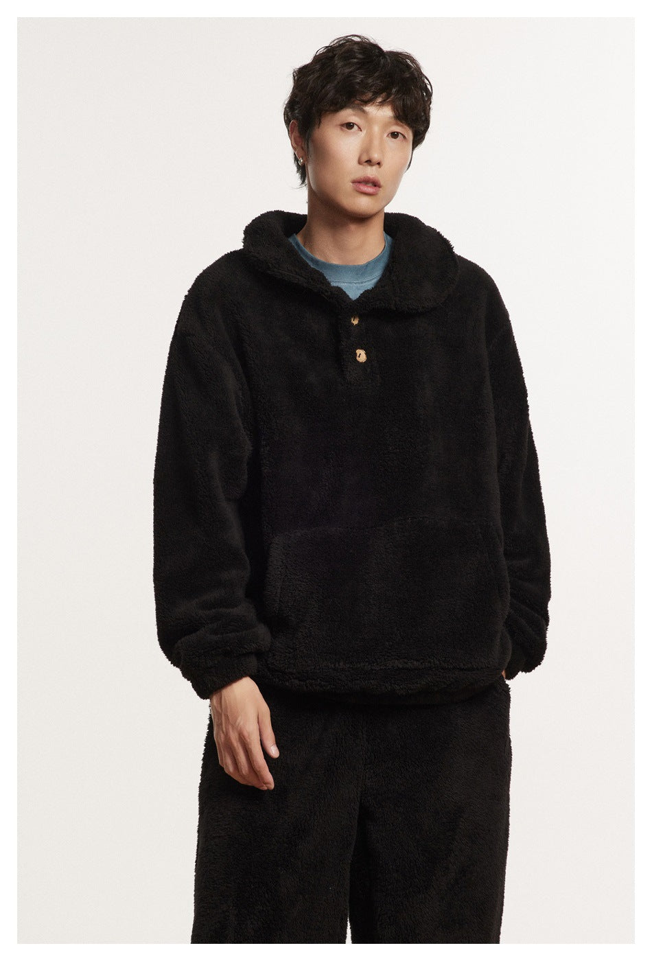 Model wearing a black plush pullover with a wide collar, two buttons, and matching pants.