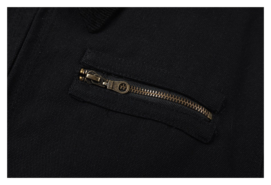 Close-up of a horizontal brass-tone zipper pocket on the black jacket.
