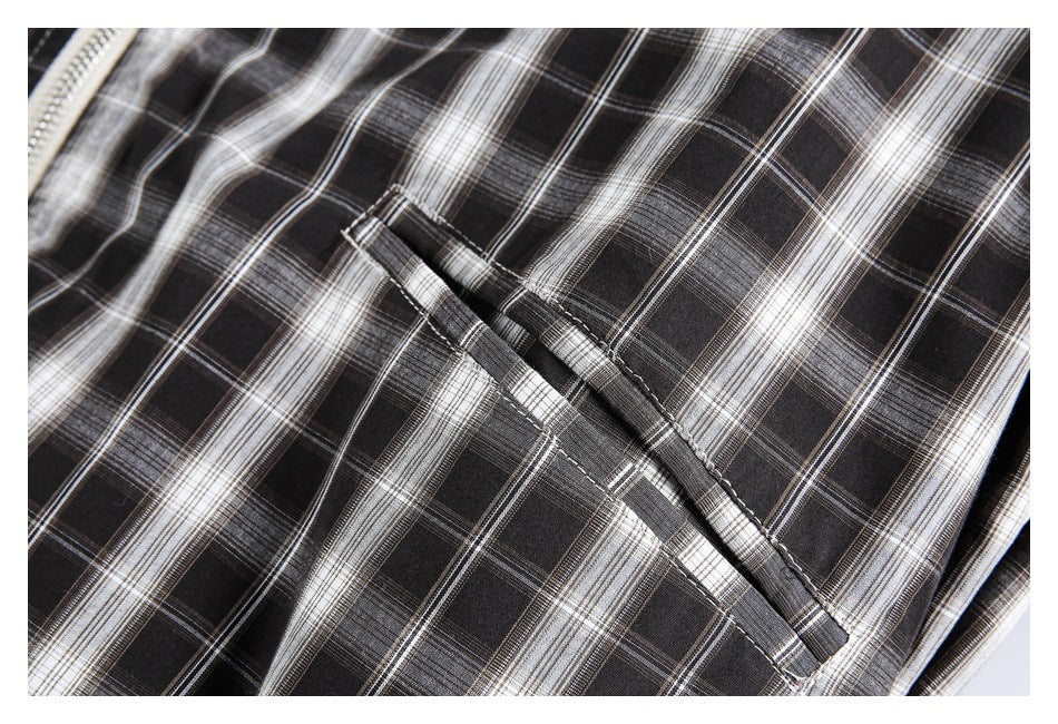 Close-up of a slanted pocket on the jacket’s black-and-white plaid fabric.