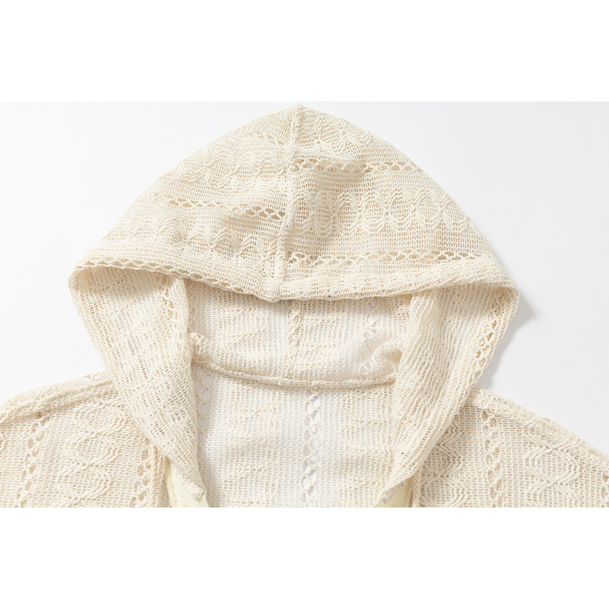 Close-up of the cream open-knit hoodie’s patterned hood and crochet stitching.