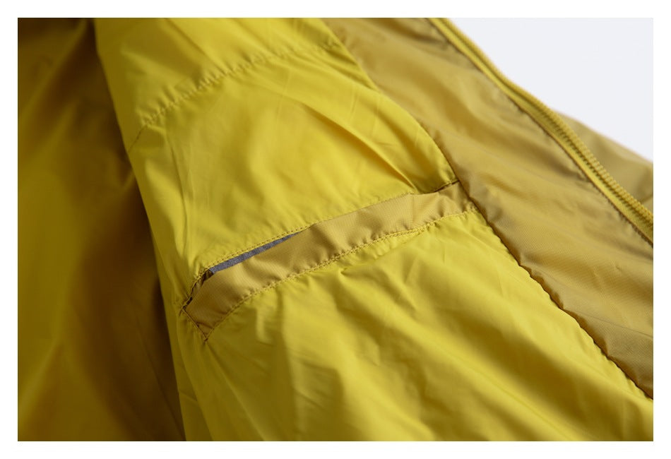 Close-up of a mustard-yellow jacket showing a seam, narrow trim, and part of the zipper.