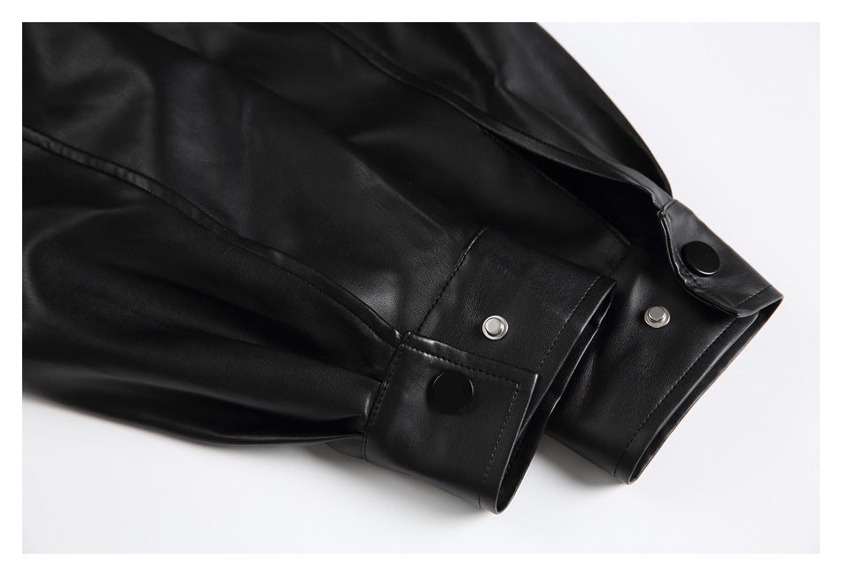 Close-up of black jacket sleeves with stitched snap-button cuffs and silver snaps.