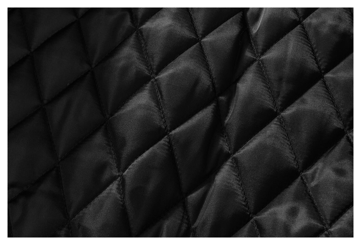 Close-up of black diamond-quilted garment lining.