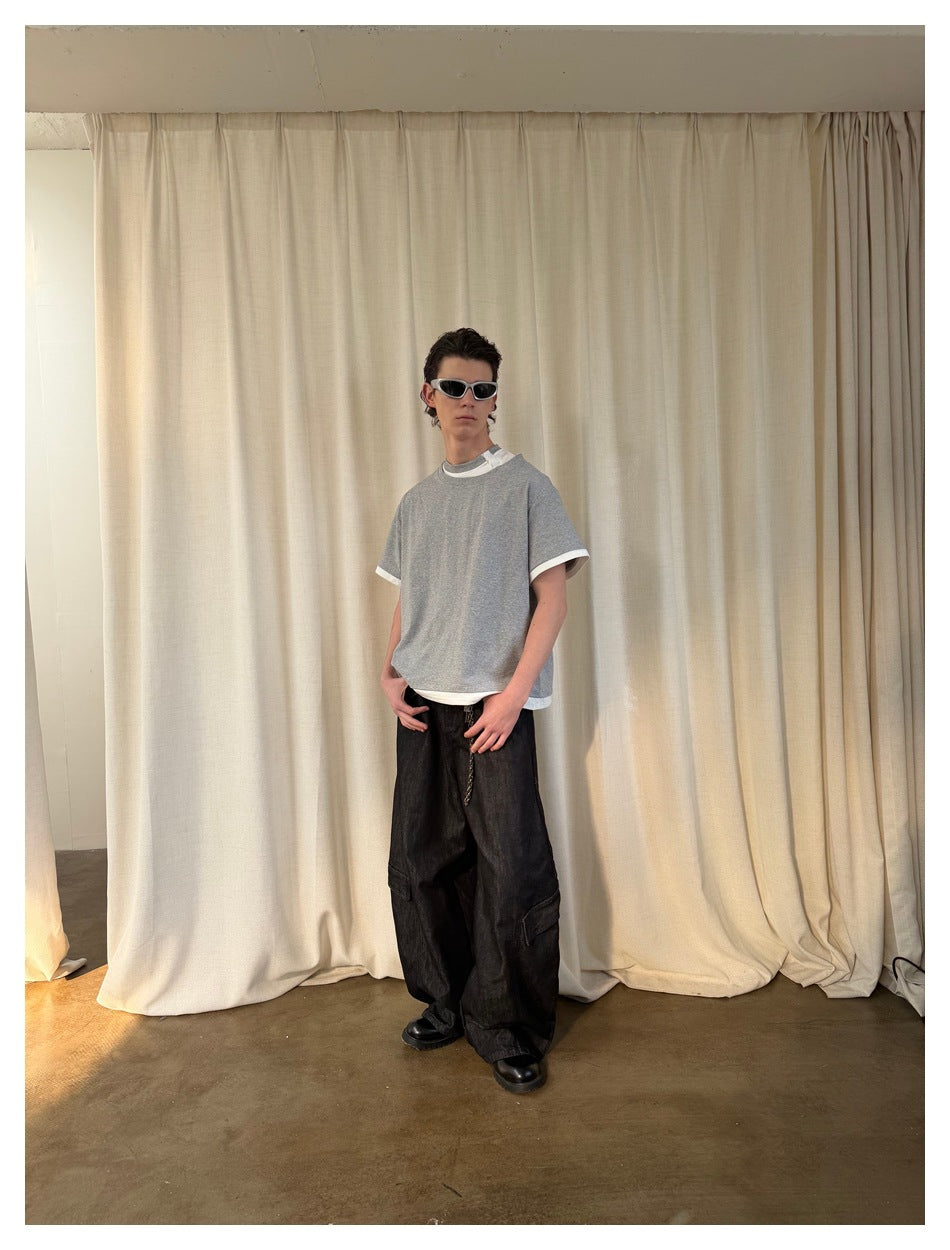 Three-quarter view of a model wearing a gray short-sleeve T-shirt with white contrast trim.