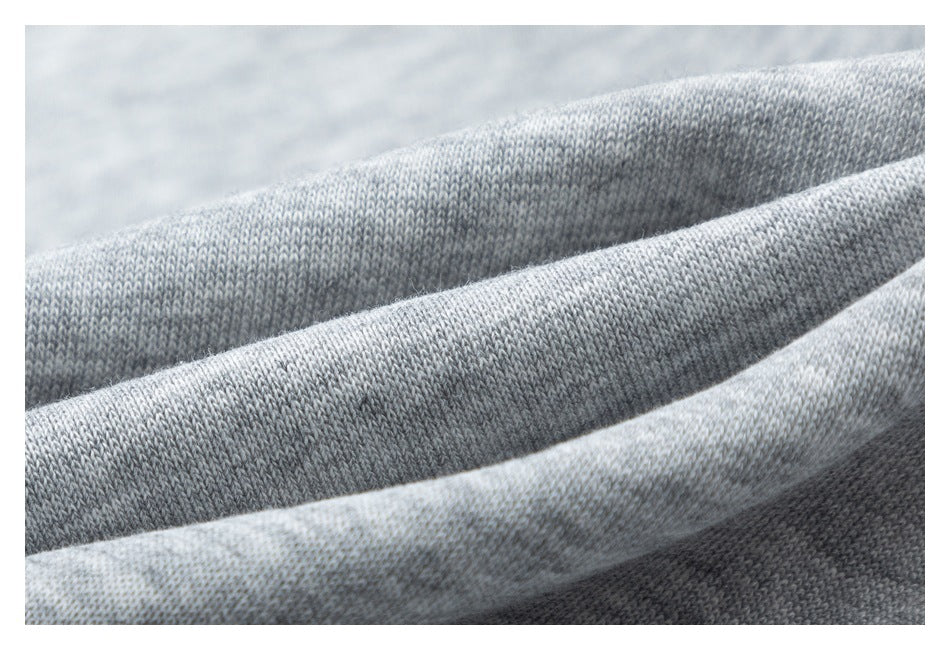 Macro view of the knit texture of light gray heathered shorts fabric.