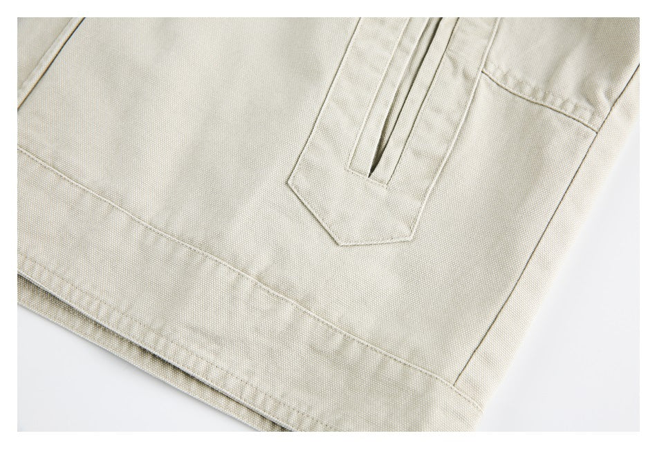 Close-up of a light beige garment showing a stitched pocket opening and hem.