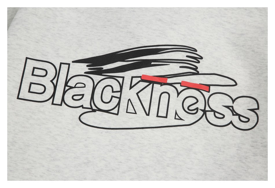 Close-up of the sweatshirt's outlined black “Blackness” chest graphic with red accents.