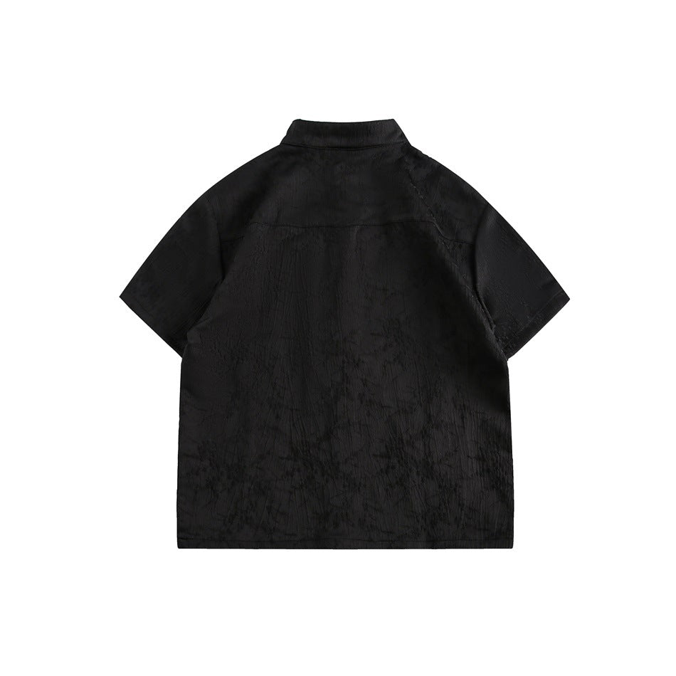 Back view of a black short-sleeve shirt with a stand collar and subtle textured fabric.
