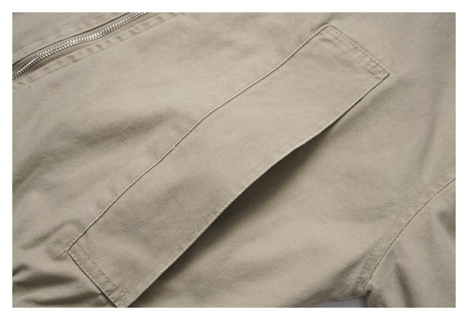 Close-up of a diagonal pocket on the light taupe jacket beside the zipper.
