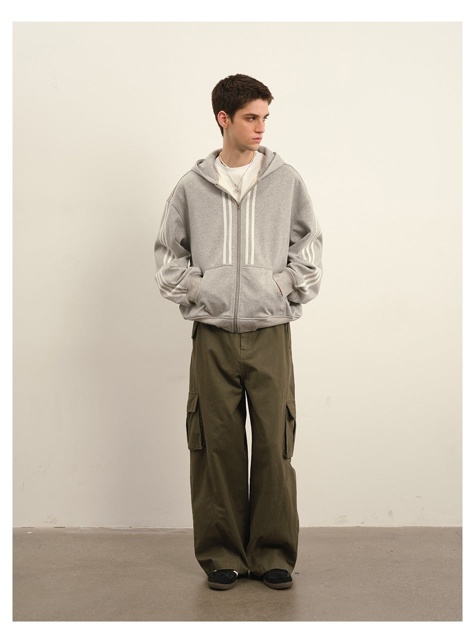 Model wearing a gray zip hoodie with white stripe details and olive cargo trousers.