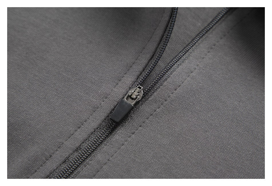 Close-up of a dark zipper and stitching on charcoal gray fabric.
