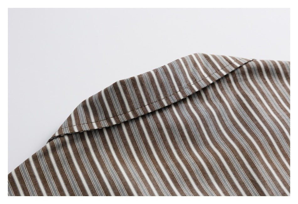 Close-up of the folded collar on a brown, gray, and white striped shirt.