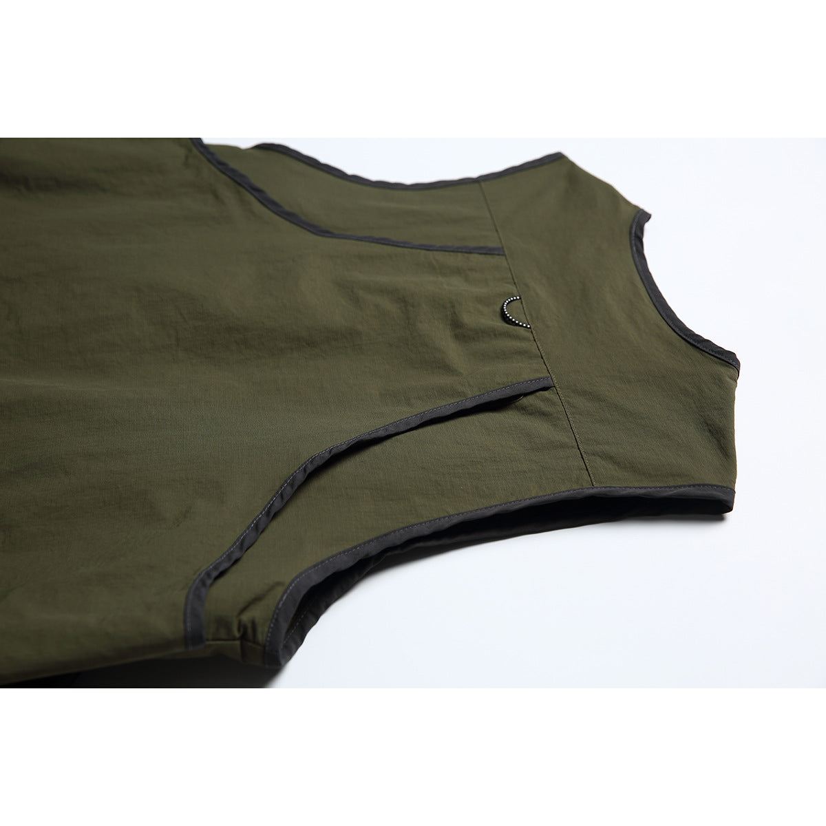Close-up of the olive vest's plain back panel, curved seams, and black edge binding.