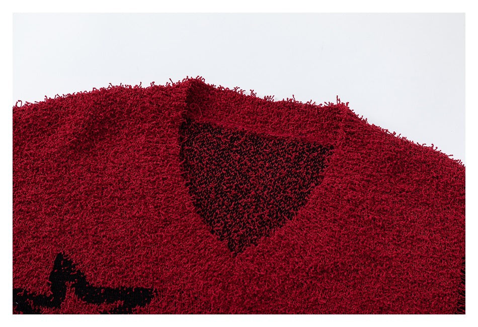 Close-up of a shaggy red scarf with a black knitted motif, shown within a white border.