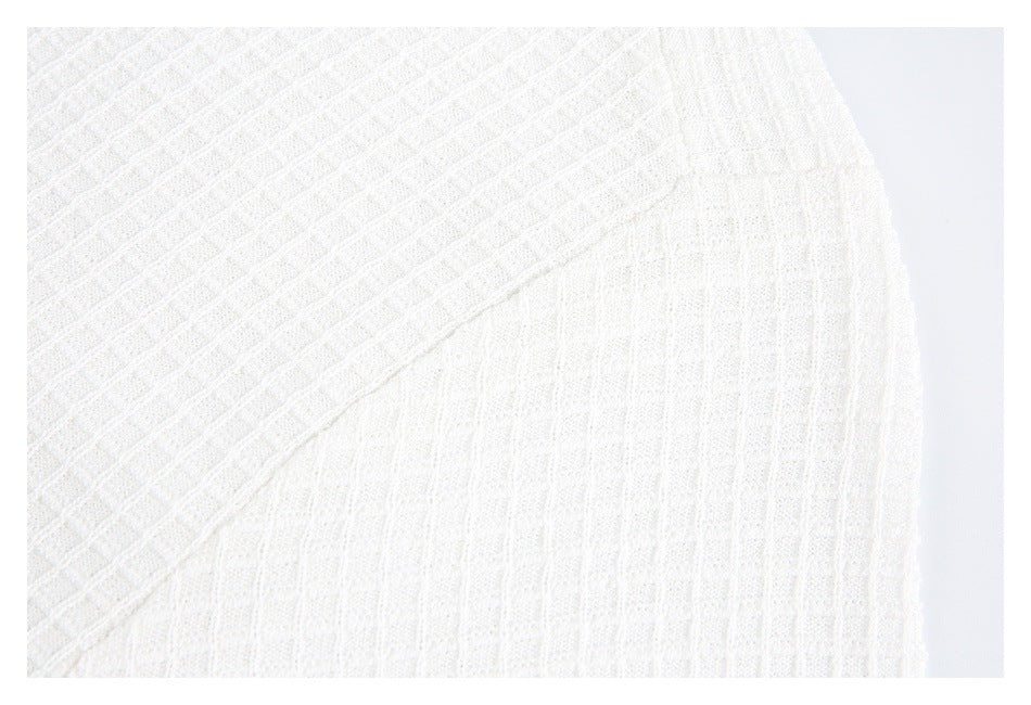 Close-up of white knit fabric showing a diagonal seam between textured panels.