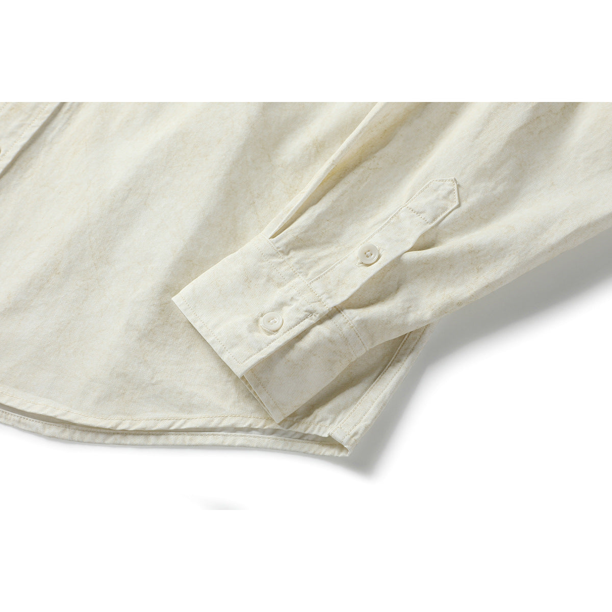 Close-up of an ivory shirt sleeve and cuff with two buttons and a buttoned sleeve placket.