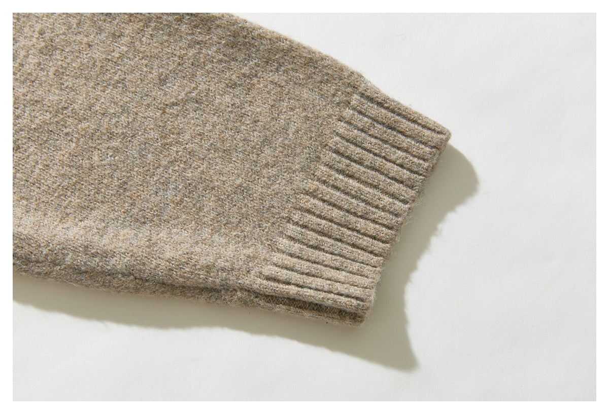 Close-up of a beige sweater sleeve ending in a ribbed cuff.