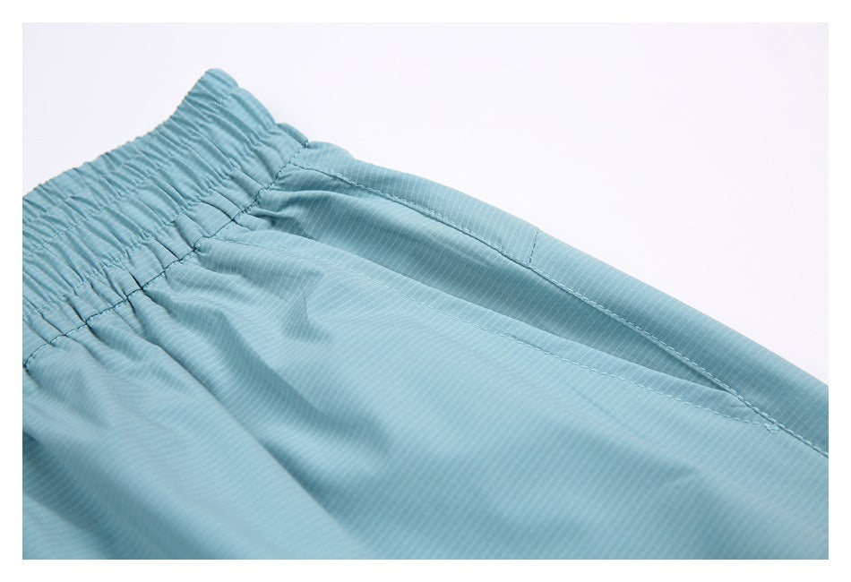Close-up of a side pocket opening and gathered waistband on the light blue shorts.