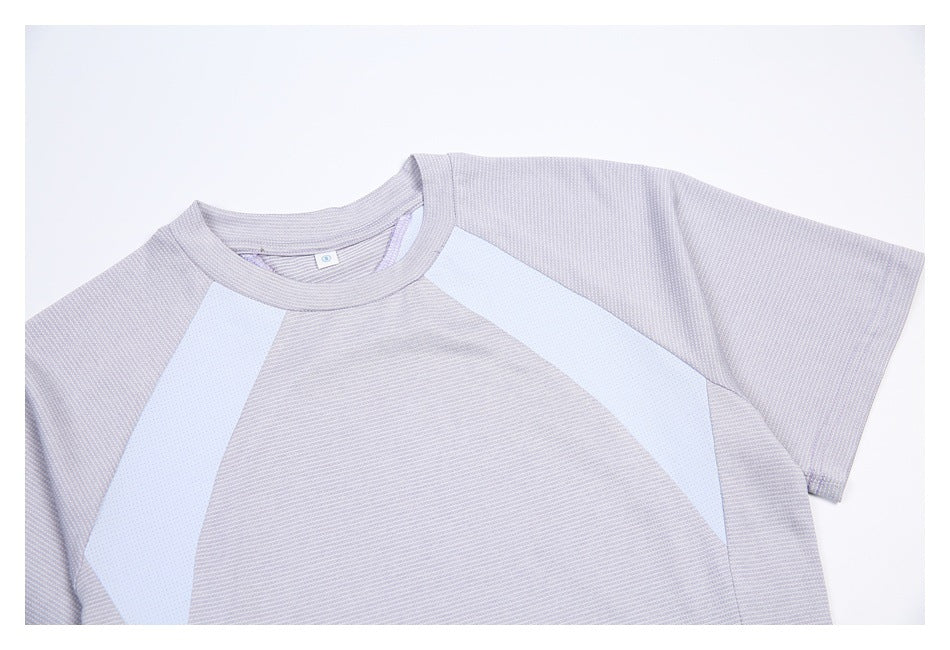 Close-up of a pale lavender tee showing its crew neckline, short sleeve, and white curved front panels.