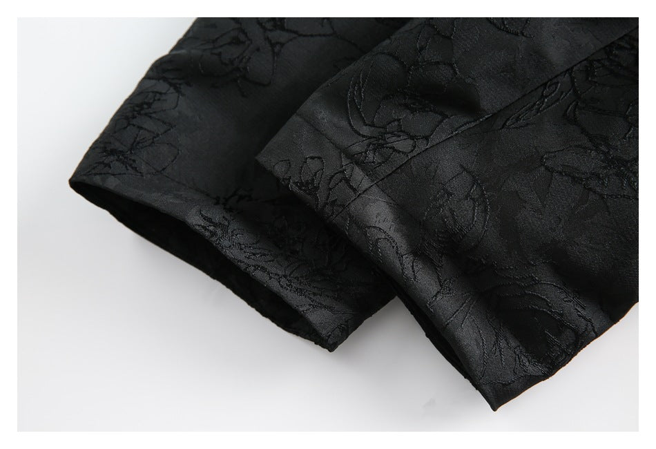 Close-up of the black floral-patterned garment's folded sleeve or hem edges.