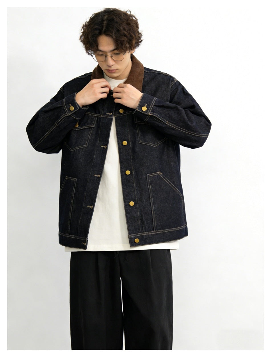 Model wearing an open dark denim jacket with a brown collar, gold-tone buttons, and black trousers.