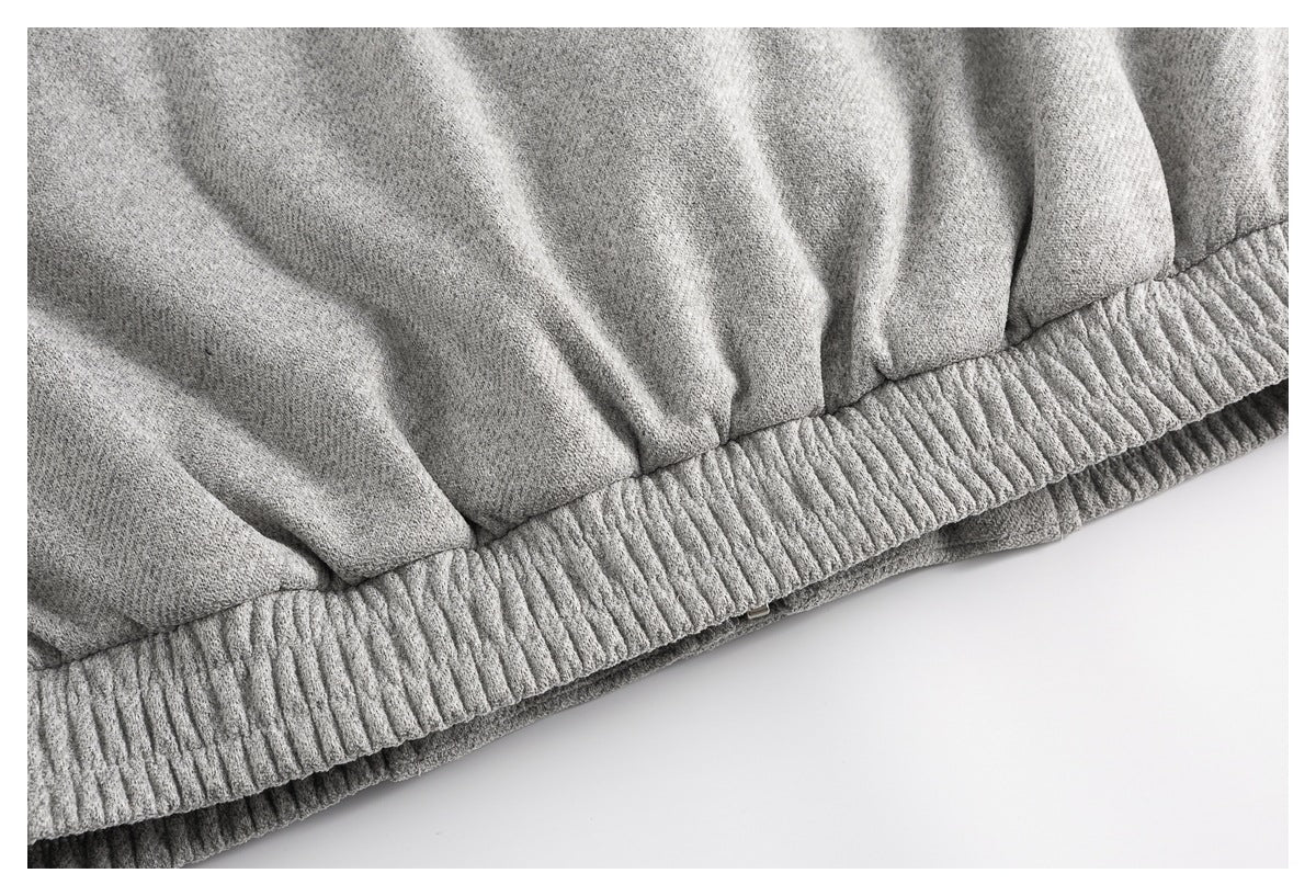 Close-up of a gray garment's gathered, ribbed elastic hem.