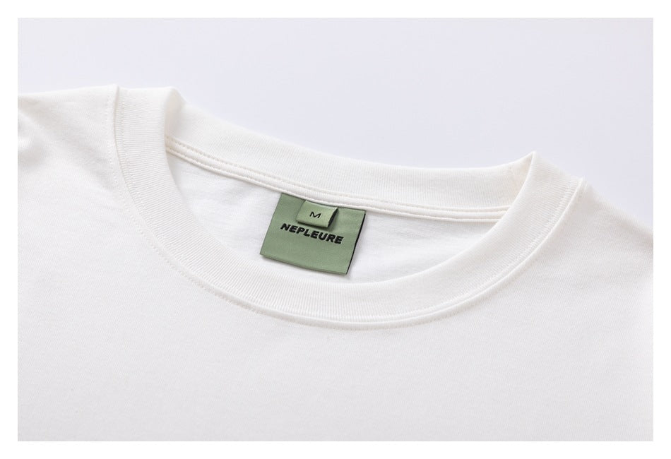 White T-shirt neckline with a sewn green NEPLEURE label marked M.