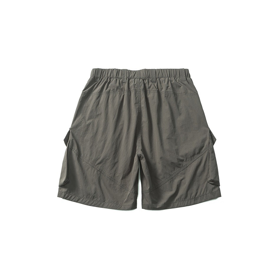 Back view of gray-green cargo shorts with elastic waistband and diagonal seams, flat lay