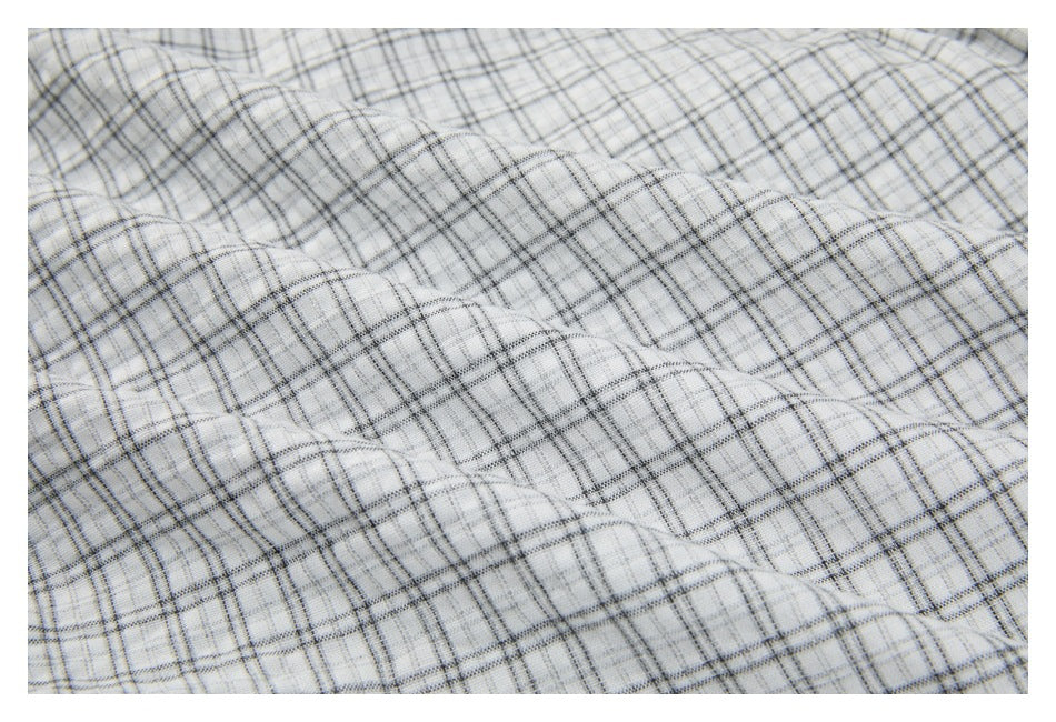Close-up showing the gray plaid fabric draped in soft folds.