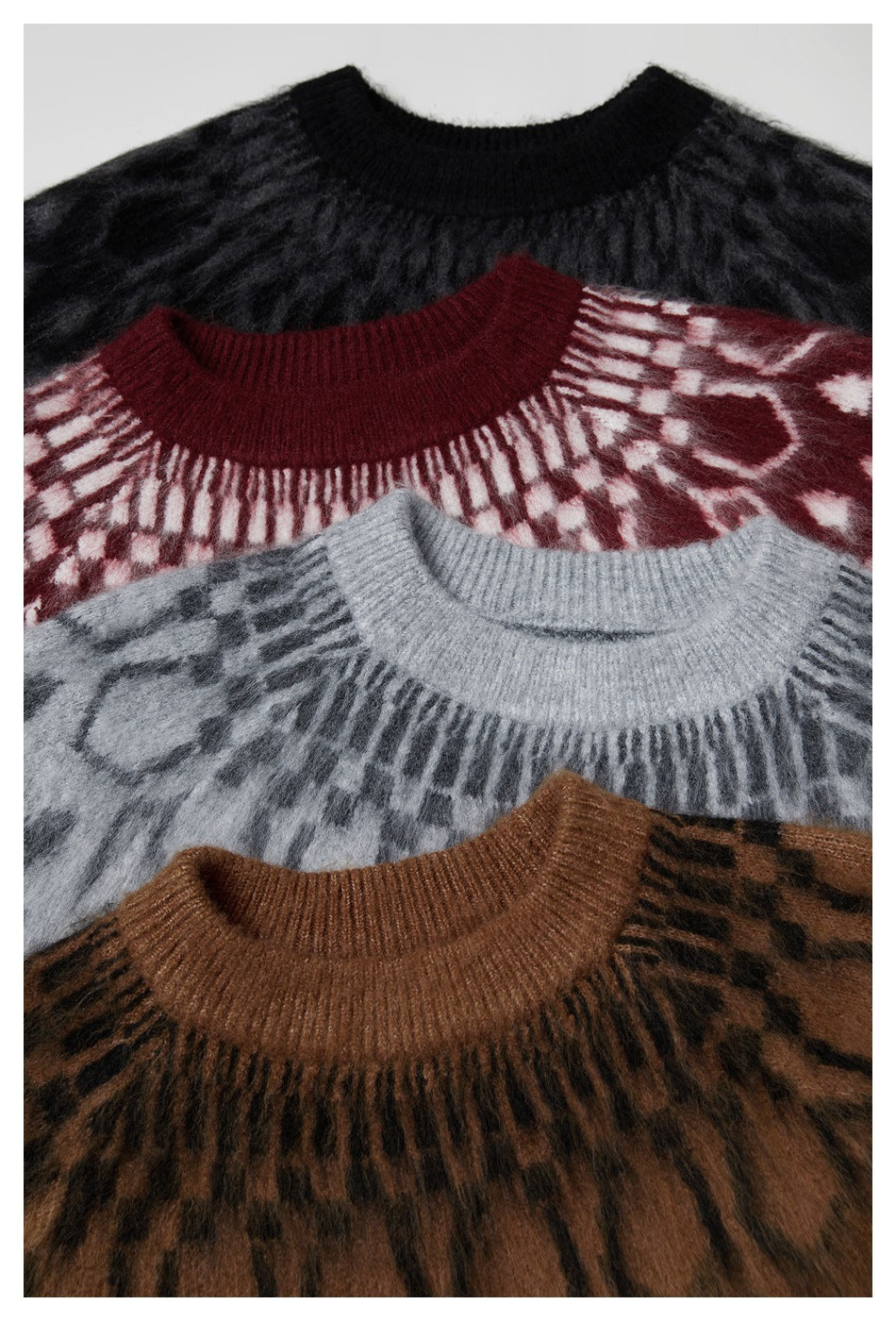 Close-up of round-neck patterned knit sweaters in black, burgundy, gray, and brown colorways.