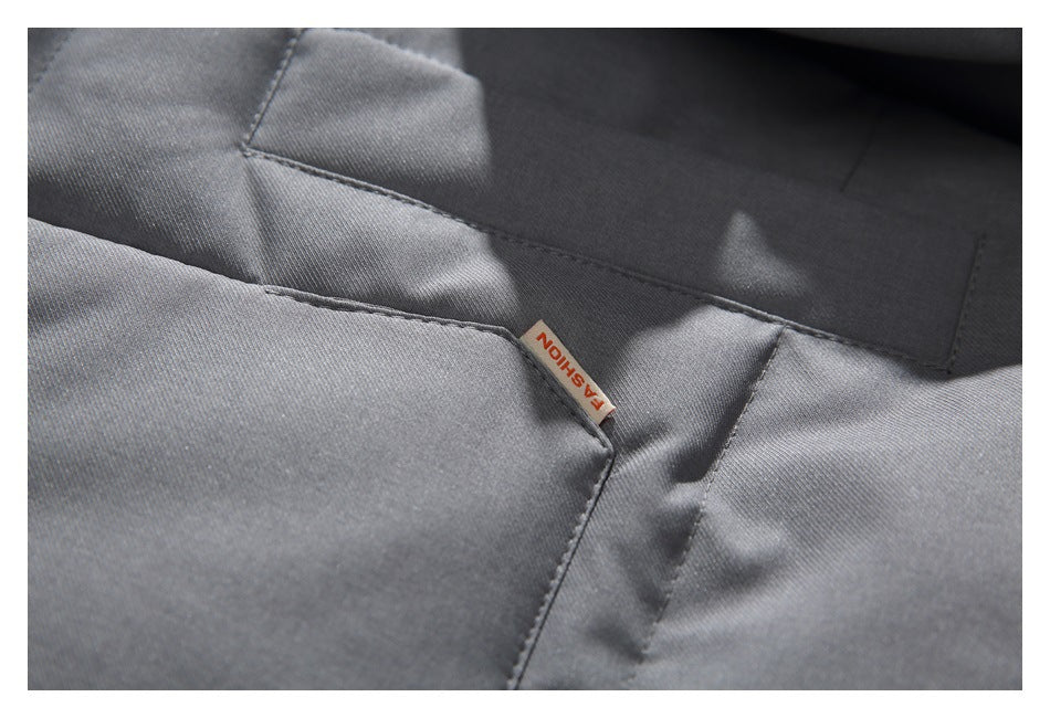 Close-up of a small FASHION tag at the seam of a gray jacket pocket.