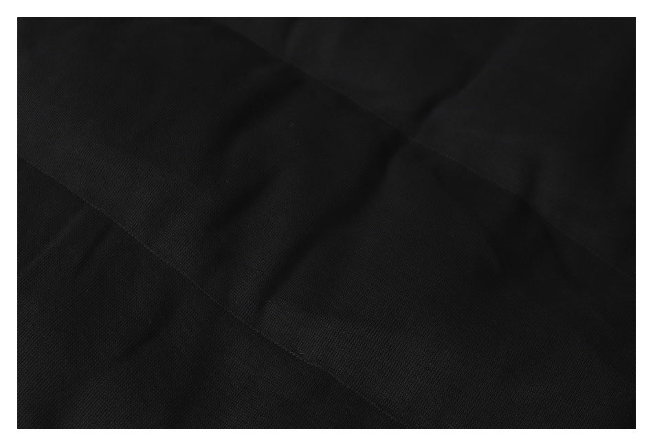Close-up of black fabric showing a curved seam and panel stitching.