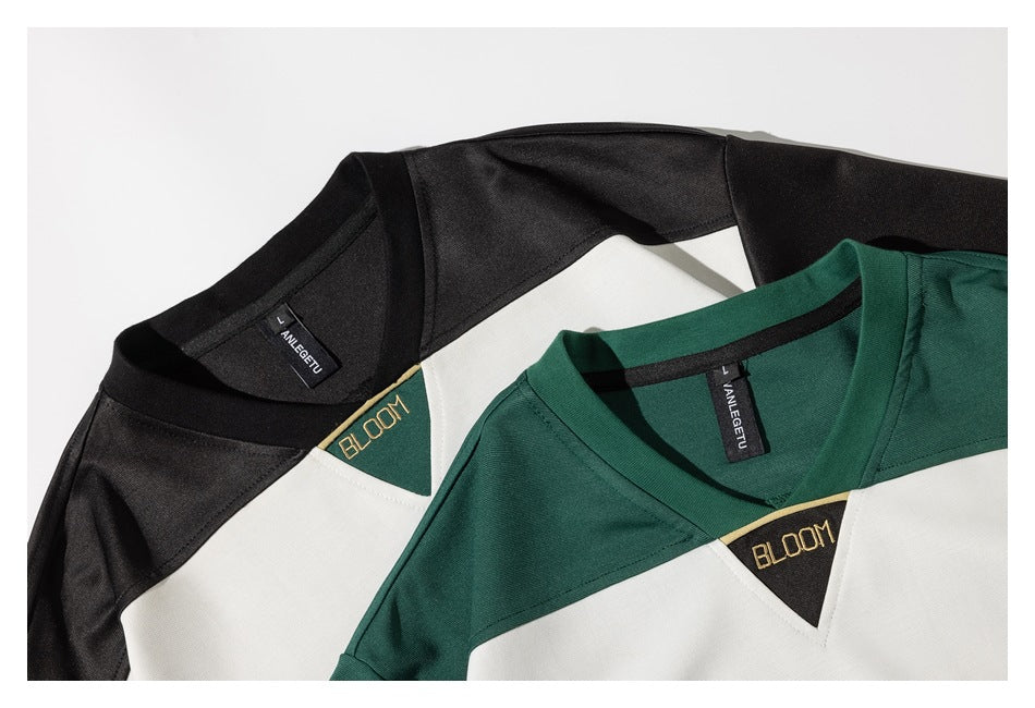 Close-up of the green and black shirts' V-necklines, white chest panels, labels, and triangular BLOOM patches.