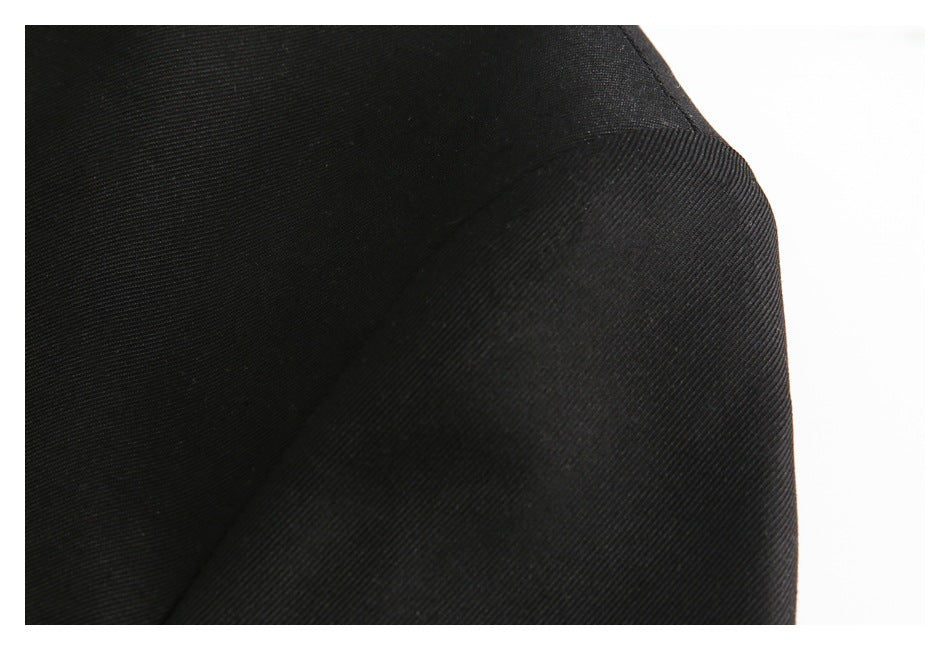 Close-up of the black jacket's shoulder seam and textured fabric.