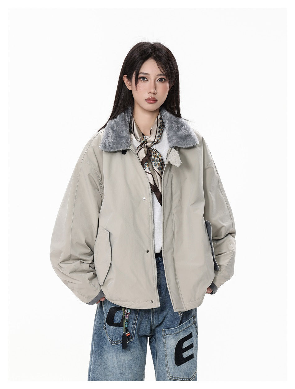 Model wearing a light gray jacket with a gray pile collar, open at the front, over a white top, scarf and jeans