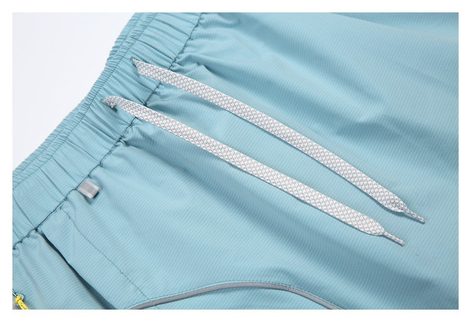Close-up of the light blue skort's patterned drawstrings, elastic waistband, and curved gray pocket trim.