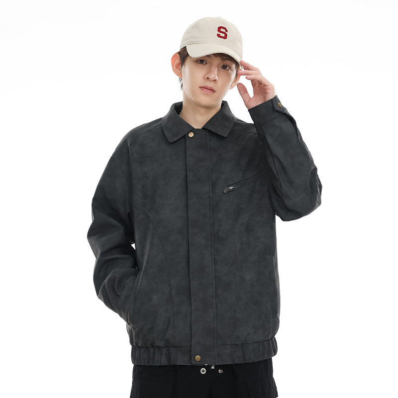 Model wearing a charcoal gray collared jacket with a concealed front closure, angled zip chest pocket, and elastic hem.