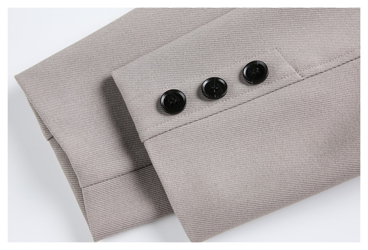 Close-up of a taupe-gray coat sleeve cuff with three black buttons and visible stitching.