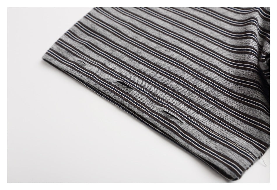 Close-up of the striped T-shirt sleeve hem and fabric, showing several small openings near the edge.