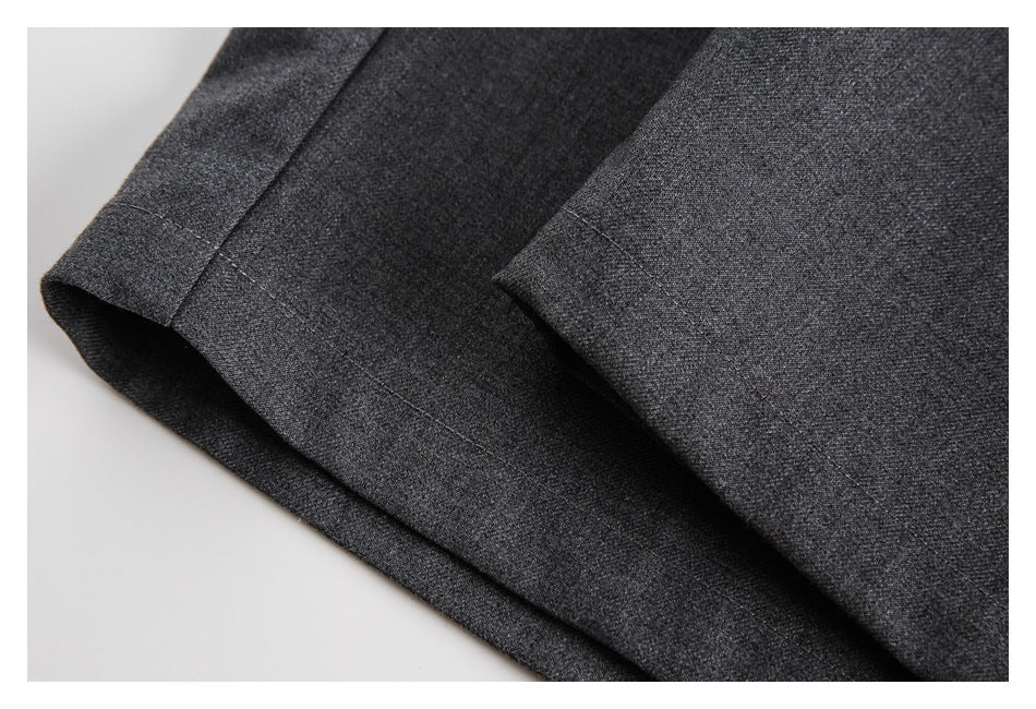 Close-up of a charcoal gray trouser leg showing the finished hem and stitching.