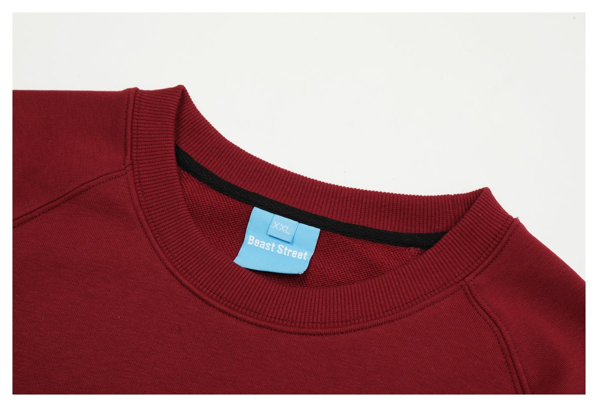 Close-up of a burgundy sweatshirt's ribbed neckline and blue Beast Street size XXL label.