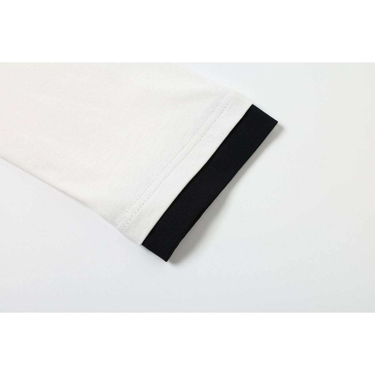 Close-up of a white sleeve hem with a contrasting black inner layer.