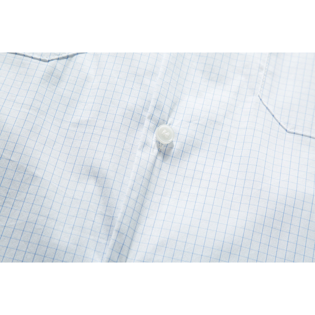 Close-up of a white shirt with a light blue grid pattern, centered on a white button and placket.