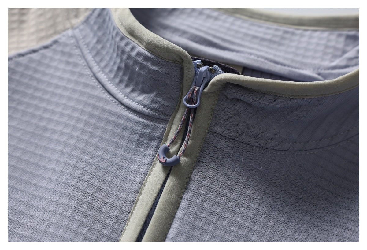 Close-up of the jacket’s collar, zipper and cord pull, showing the textured gray fabric and light-colored trim.