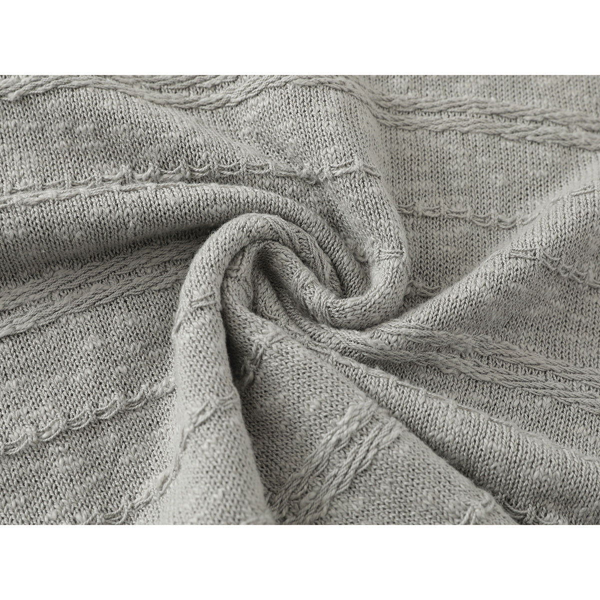 Close-up of light gray knit fabric showing raised horizontal stitch patterns and a folded section.