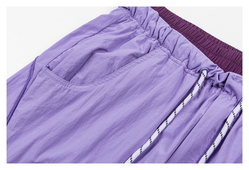 Close-up of lavender pants showing a slanted pocket, gathered waistband, and white patterned drawstrings.