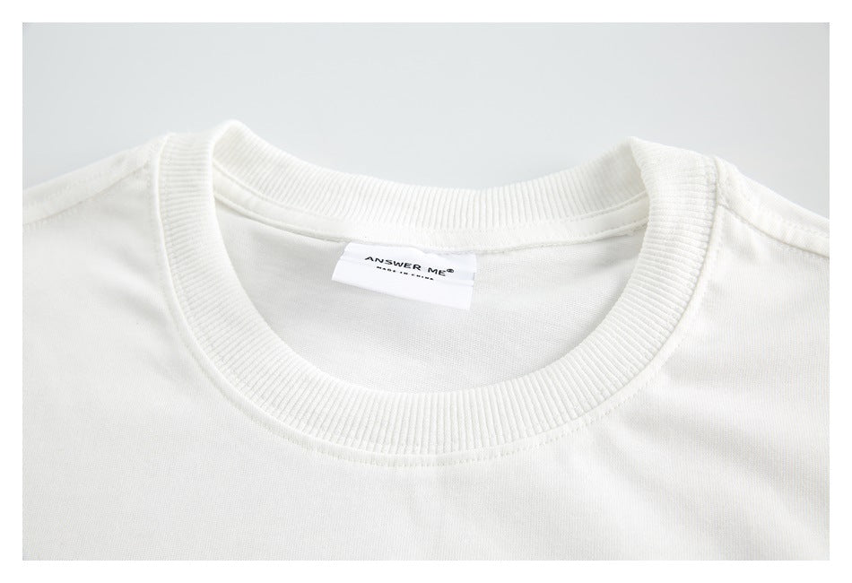 Close-up of a white top's ribbed crew neckline and sewn neck label.