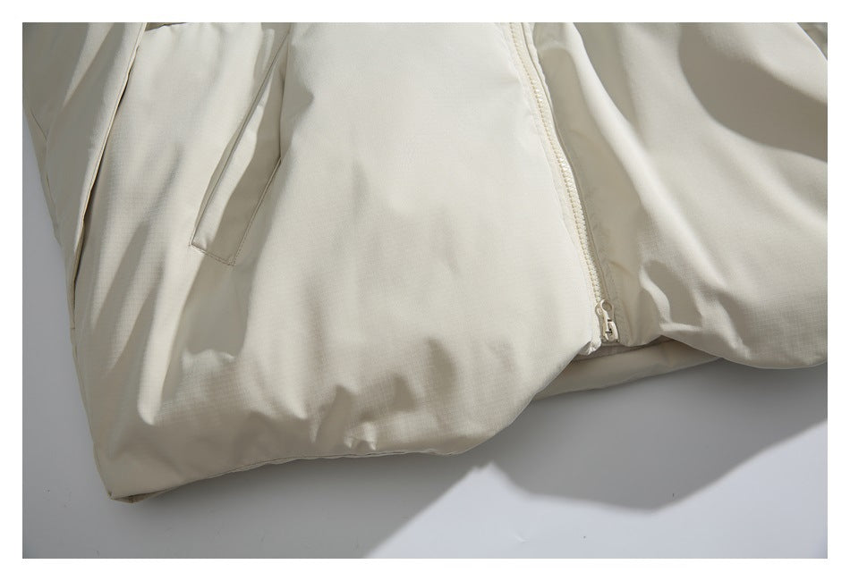 Close-up of an ivory jacket showing a slanted pocket and front zipper.
